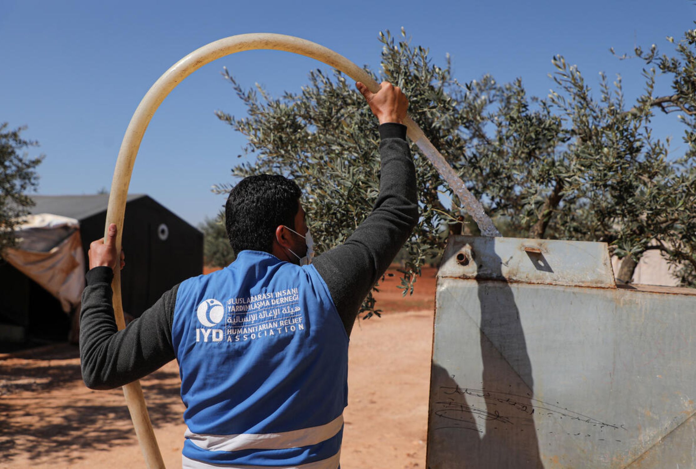 World Vision partner filling a water tank