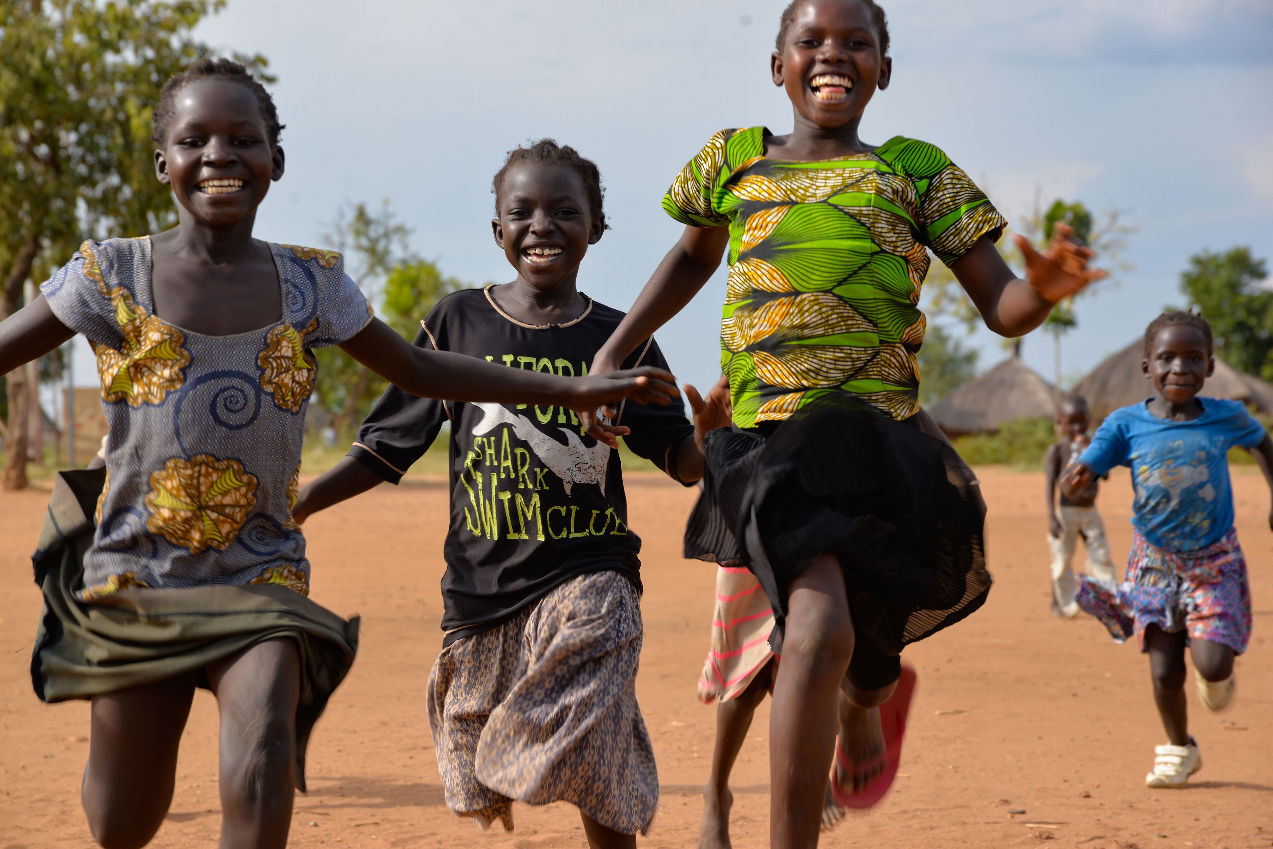 Members of a refugee children's choir race outdoors before choir practice