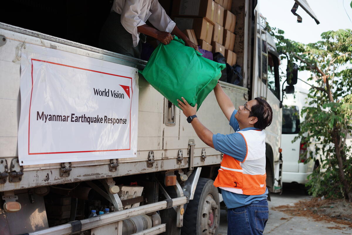Staff members distribute mini food kits in Myanmar