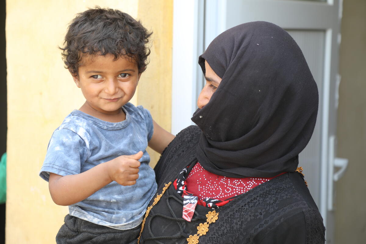Young boy being held by his mother in Syria