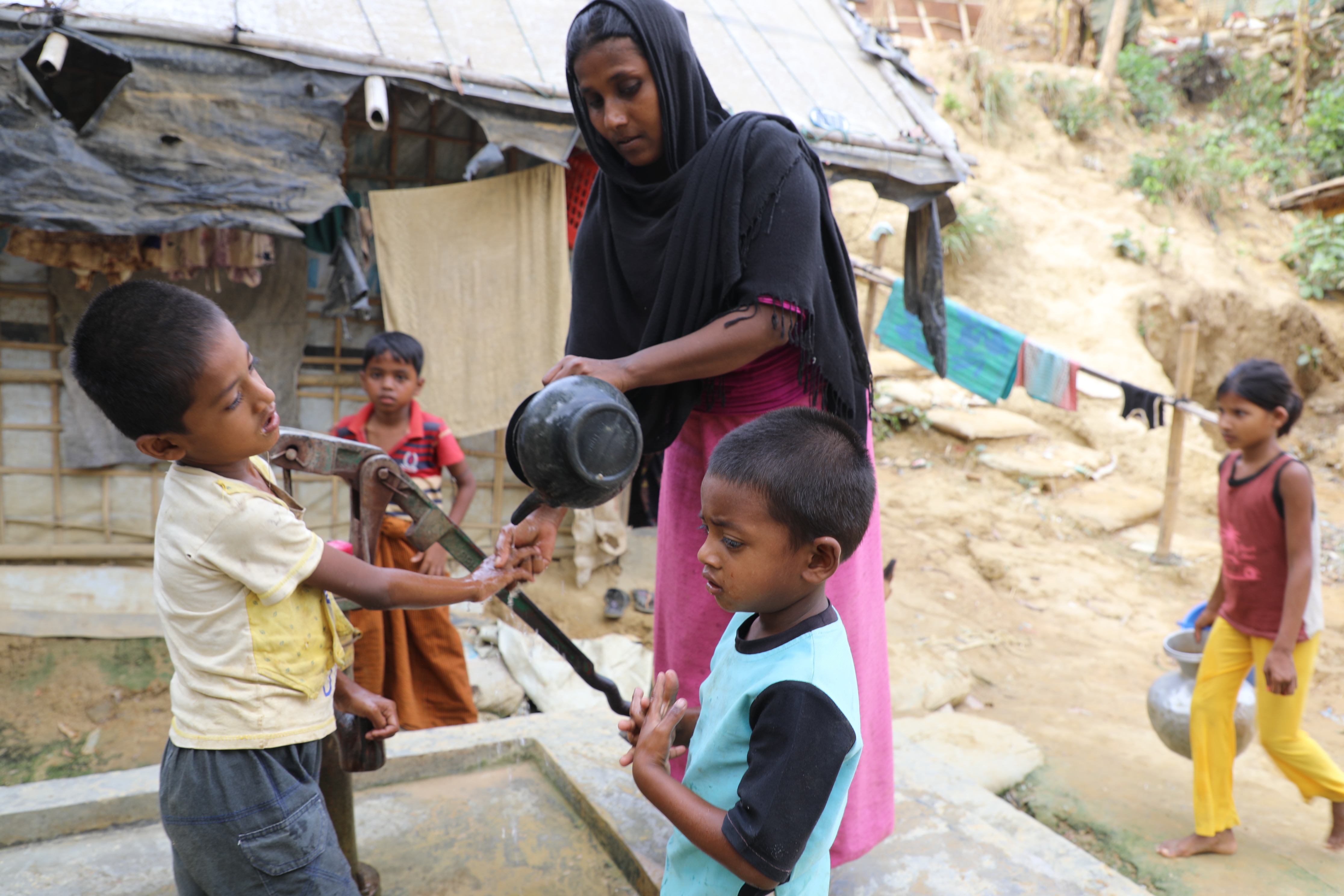 Juhara helping her sons to wash