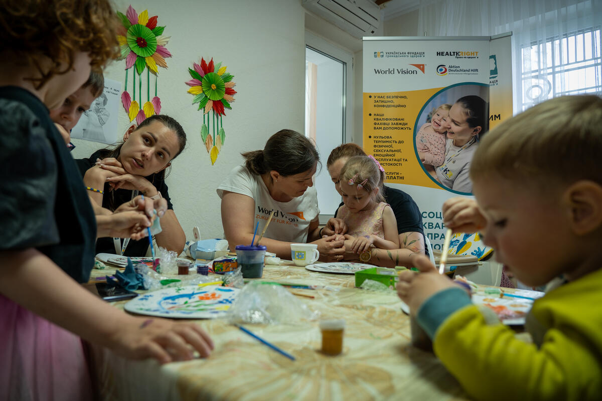 A group of children in Ukraine assisted by their carers drawing