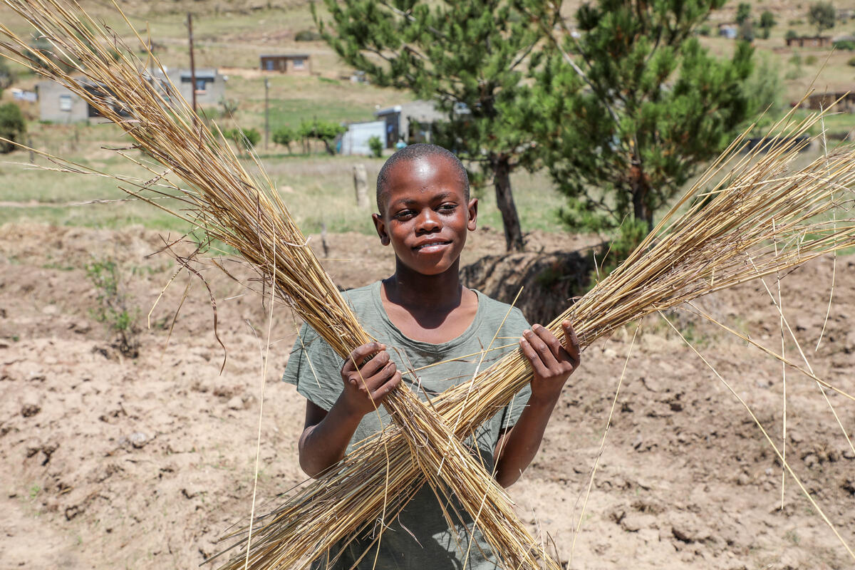 Thabang from Lesotho, carrying the grass that he and his family use to cover crops 