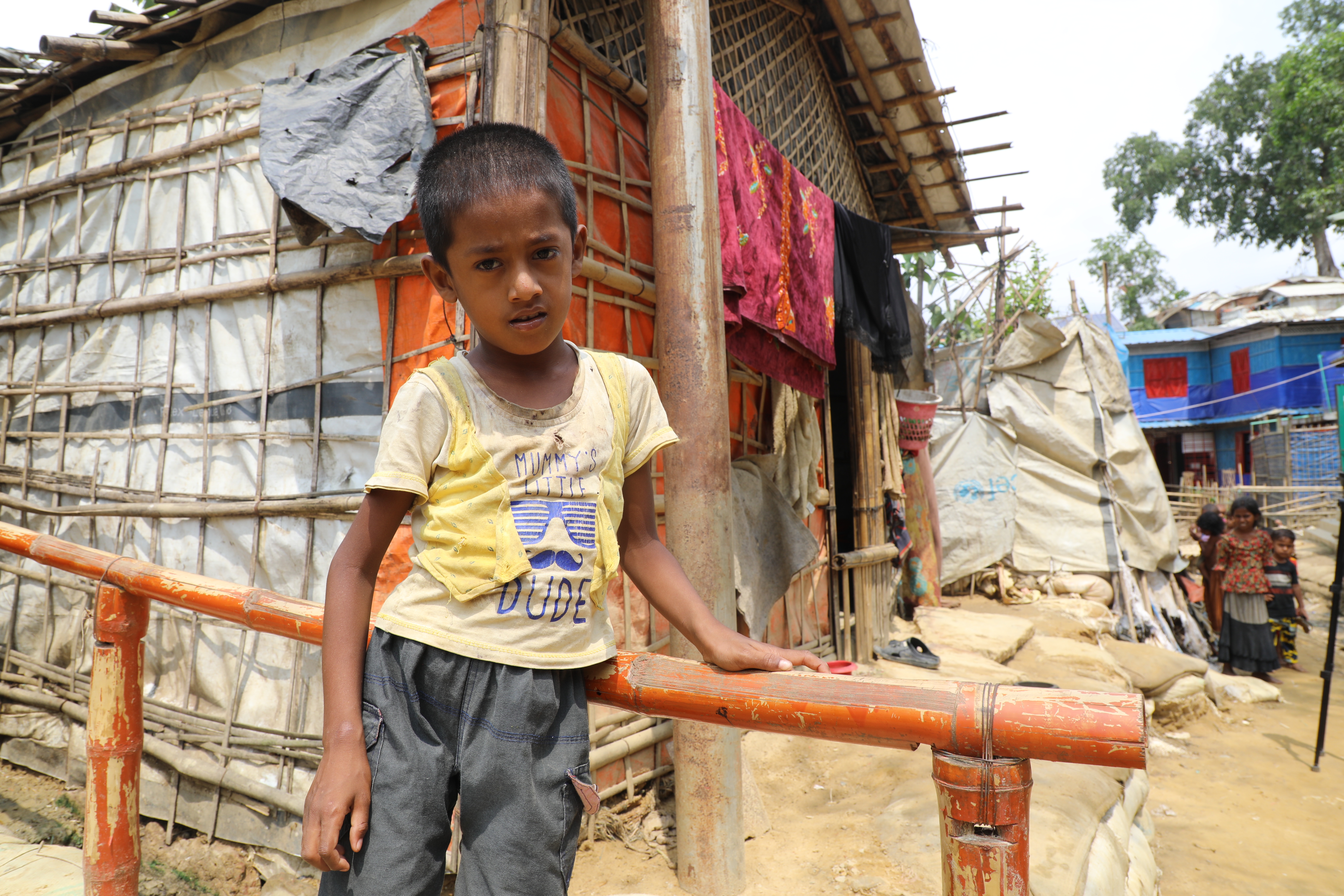 Ares standing holding the handrail that World Vision have built to make access easier.