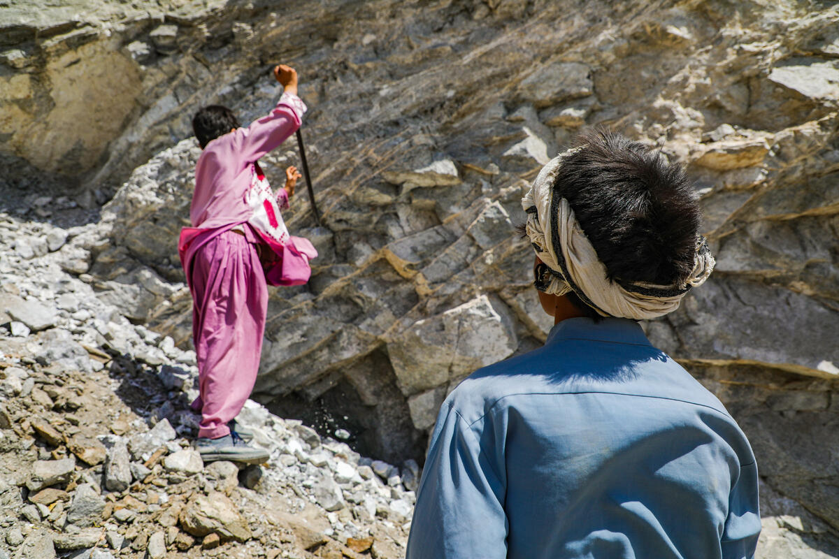 Two boys digging rocks