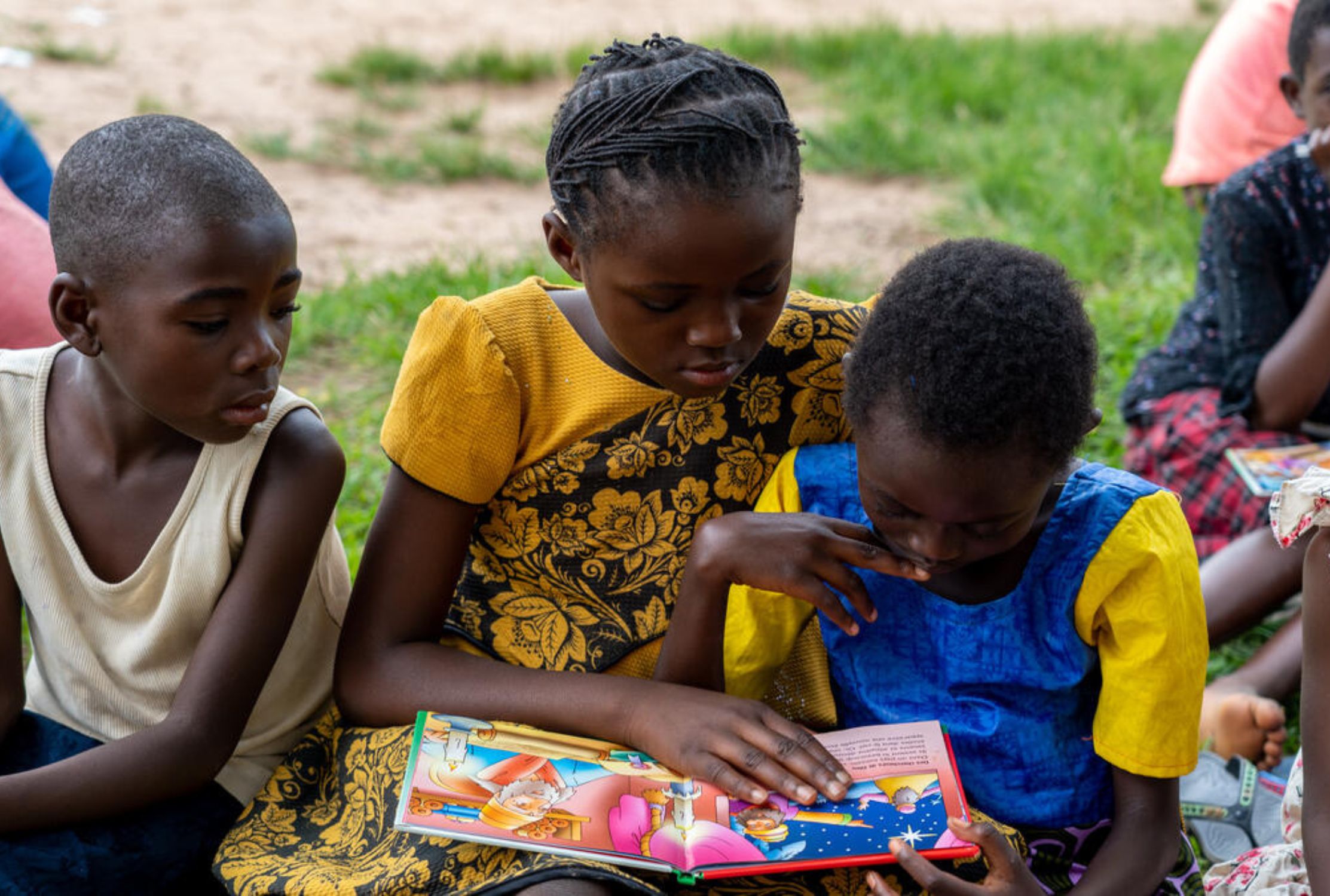 Three children reading a book together
