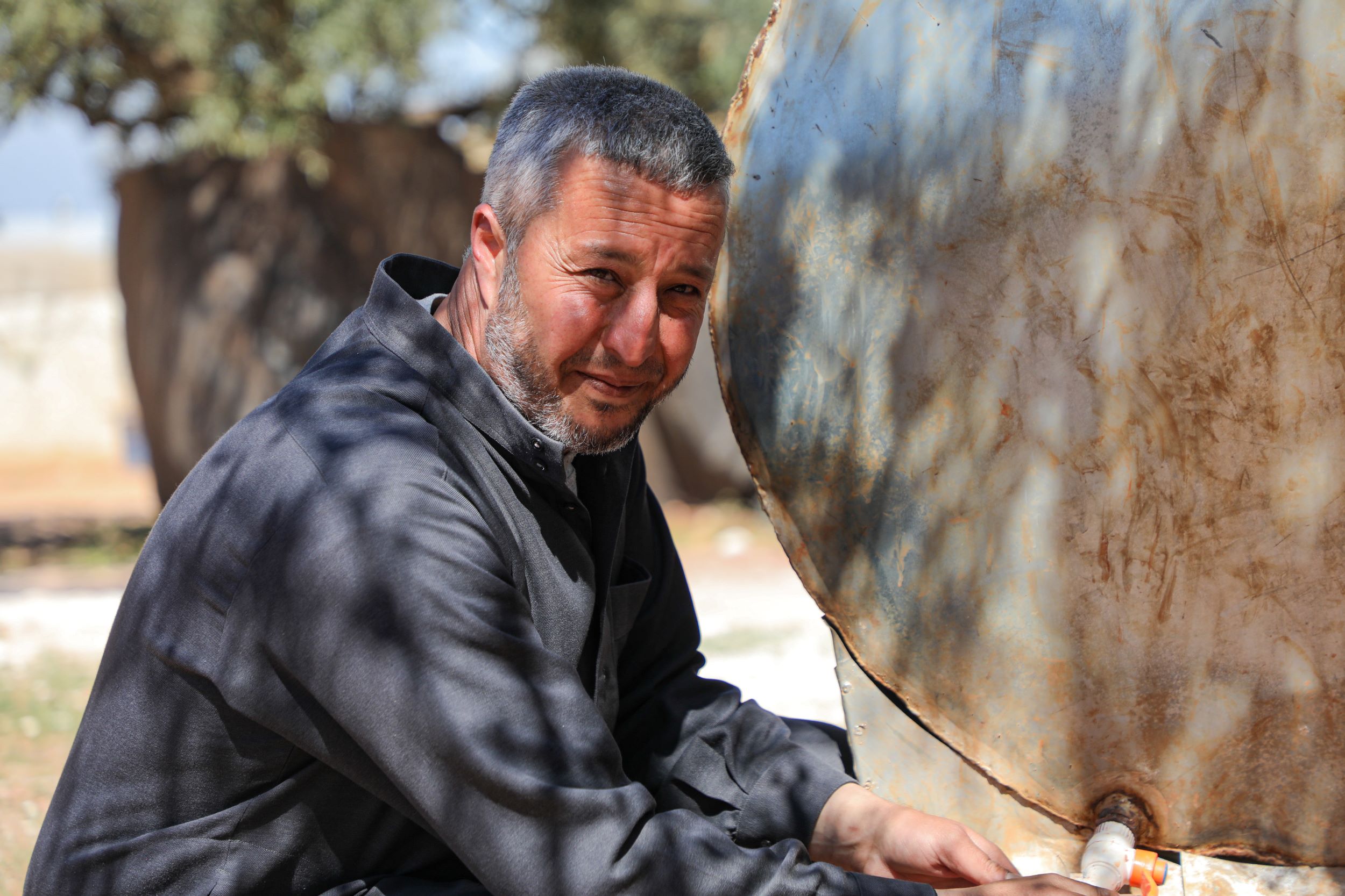 Syrian man collecting water for his family, Northwest Syria