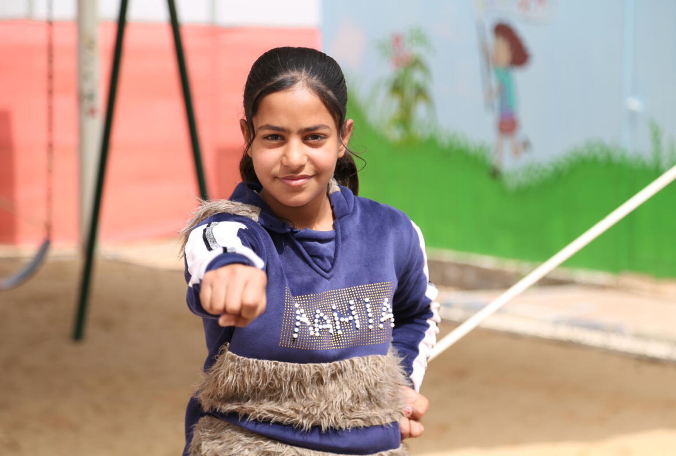 A girl shows her technique to the camera as she takes part in World Vision's karate class in Jordan