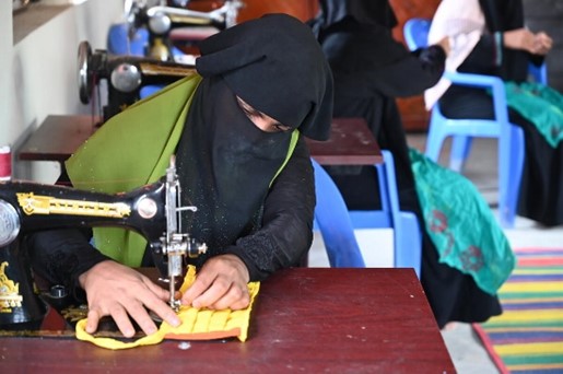 A girl using a sewing machine.