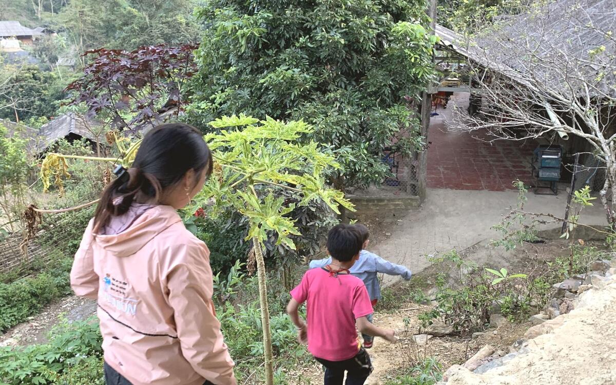 Back of heads of Vietnamese mother and son walking down a hill