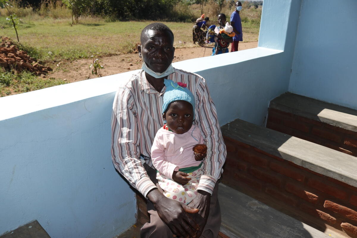 Andrea and his dad, Moses, attending the under-fives clinic at the new health centre