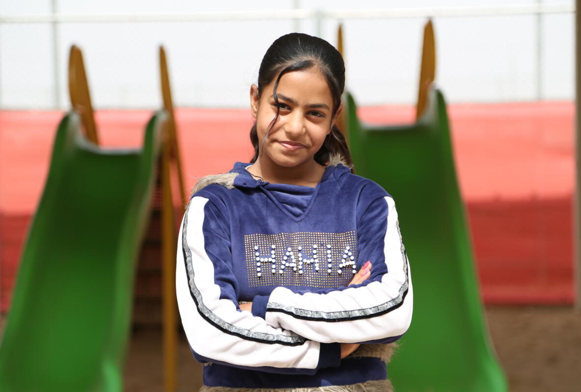 Syrian refugee girl with crossed arms