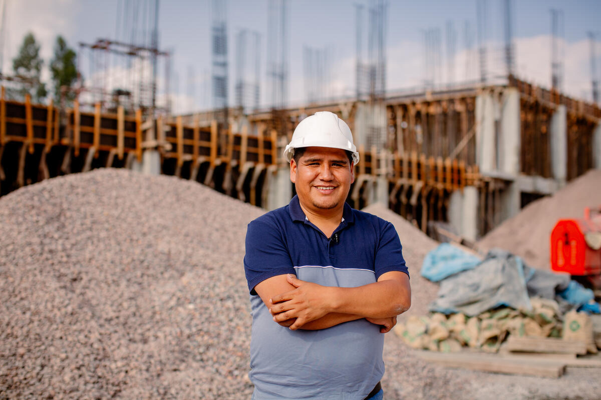Mayor and former sponsored child poses for a picture in front of a construction site