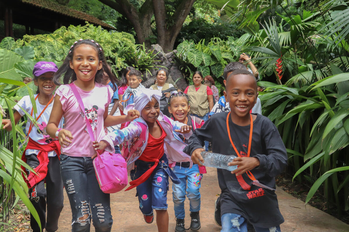 A group of sponsored children in Columbia run towards the camera