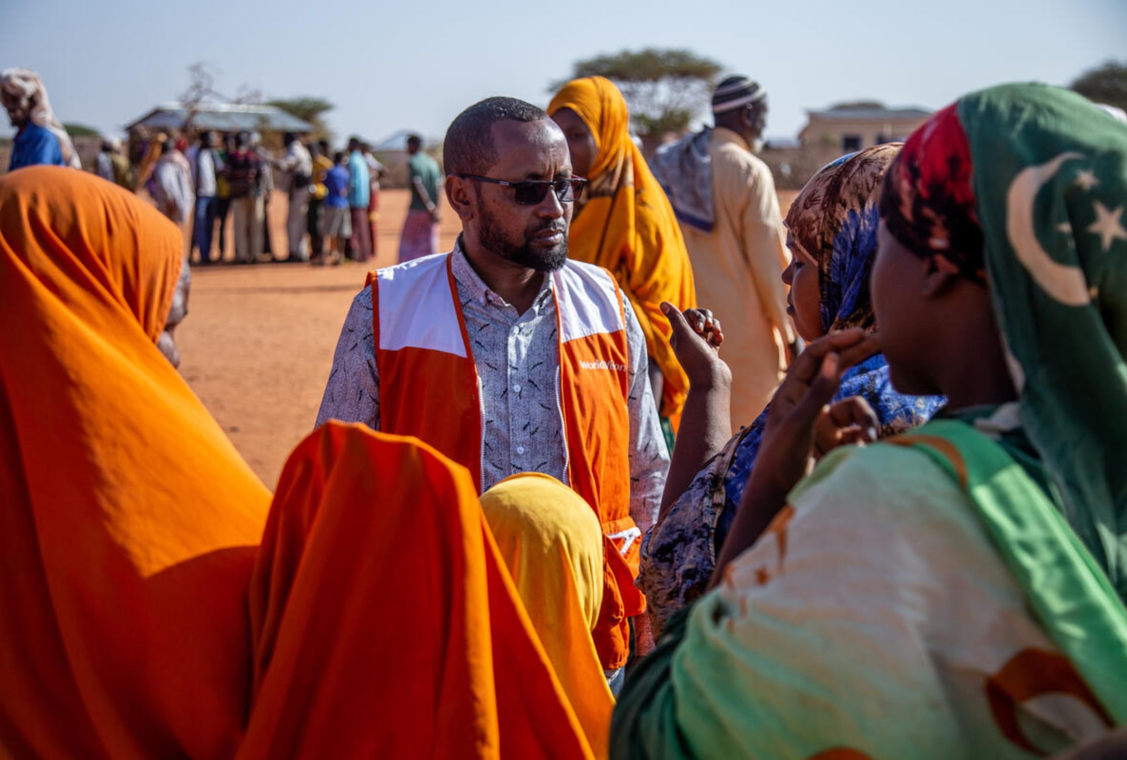 Male World Vision staff talking to a crowd of Somali people