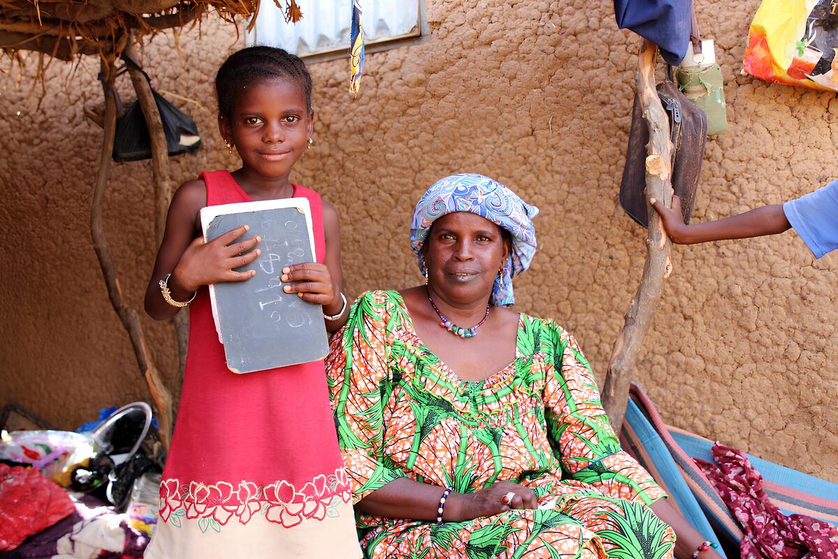 Child in a pink dress with an older woman
