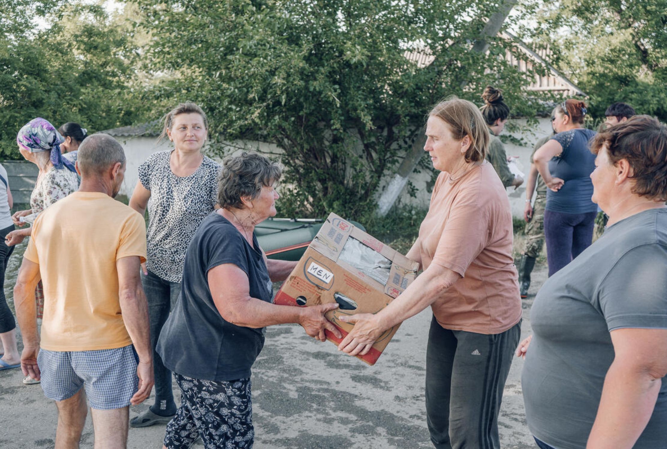 Two Ukrainian women holding a crumpled cardboard box 