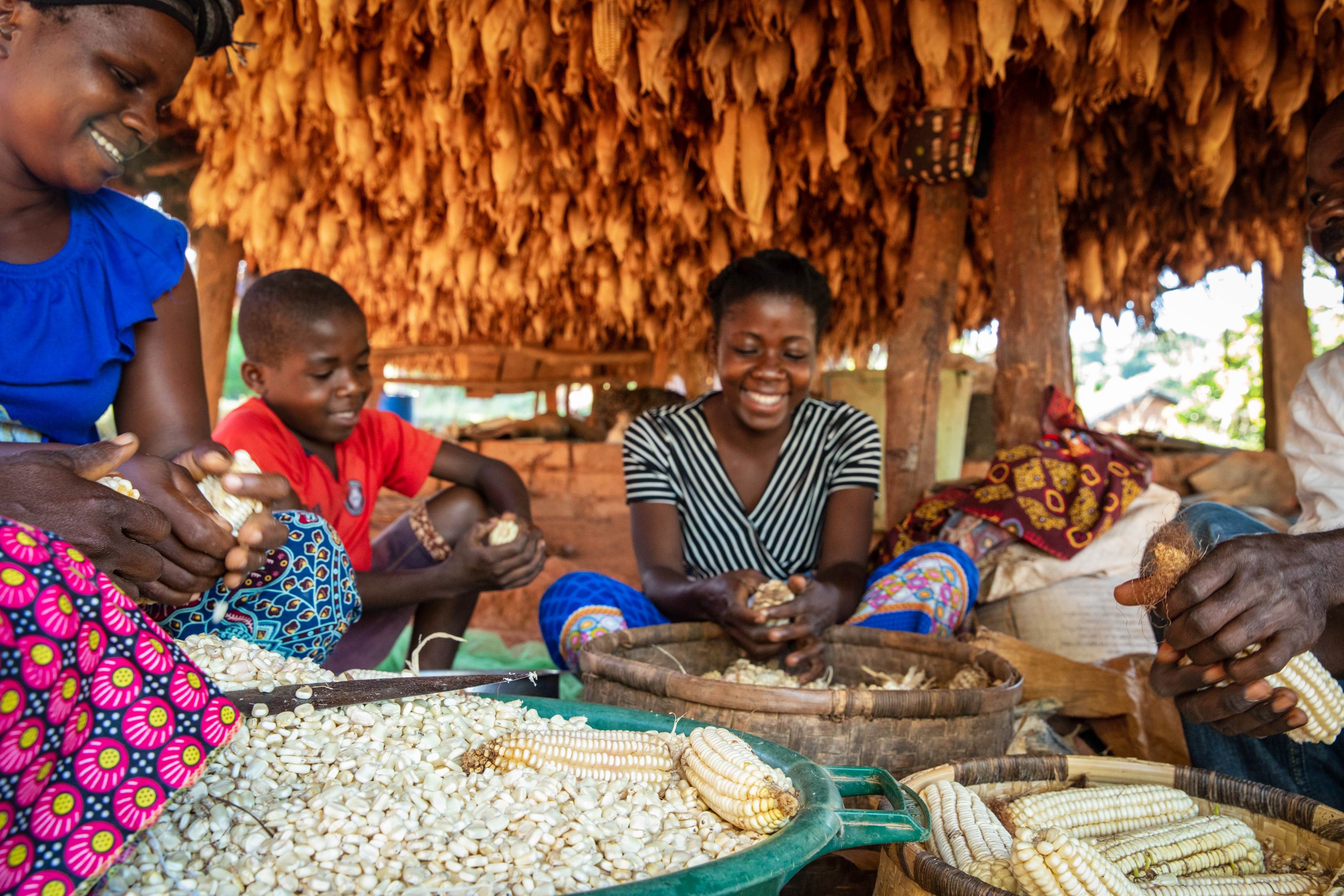 Family smile as they pass their hands through grains 