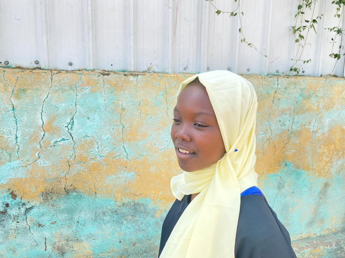 teenage girl from Sudan facing to the left, wearing a pale yellow Hijab