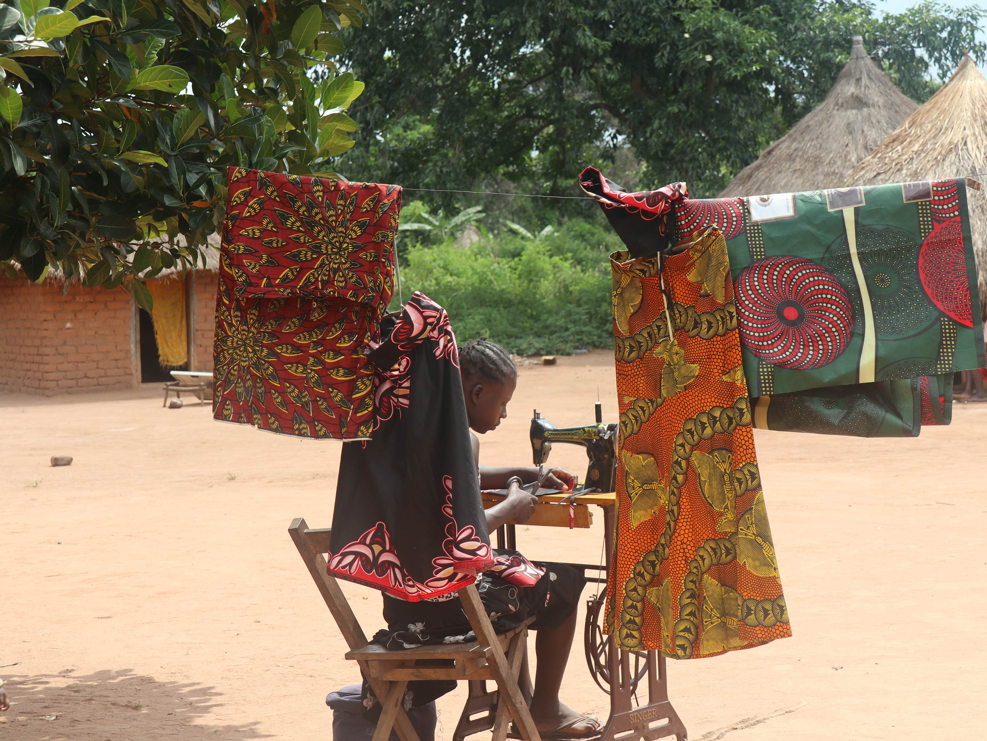 Grace, a former child soldier from South Sudan, sits at a sewing machine provided by World Vision
