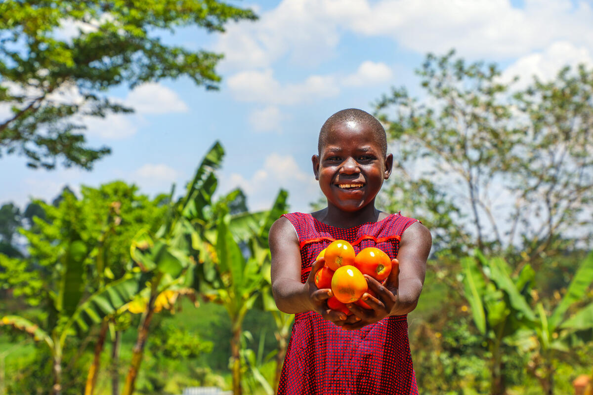 Ugandan child showing harvested fruits