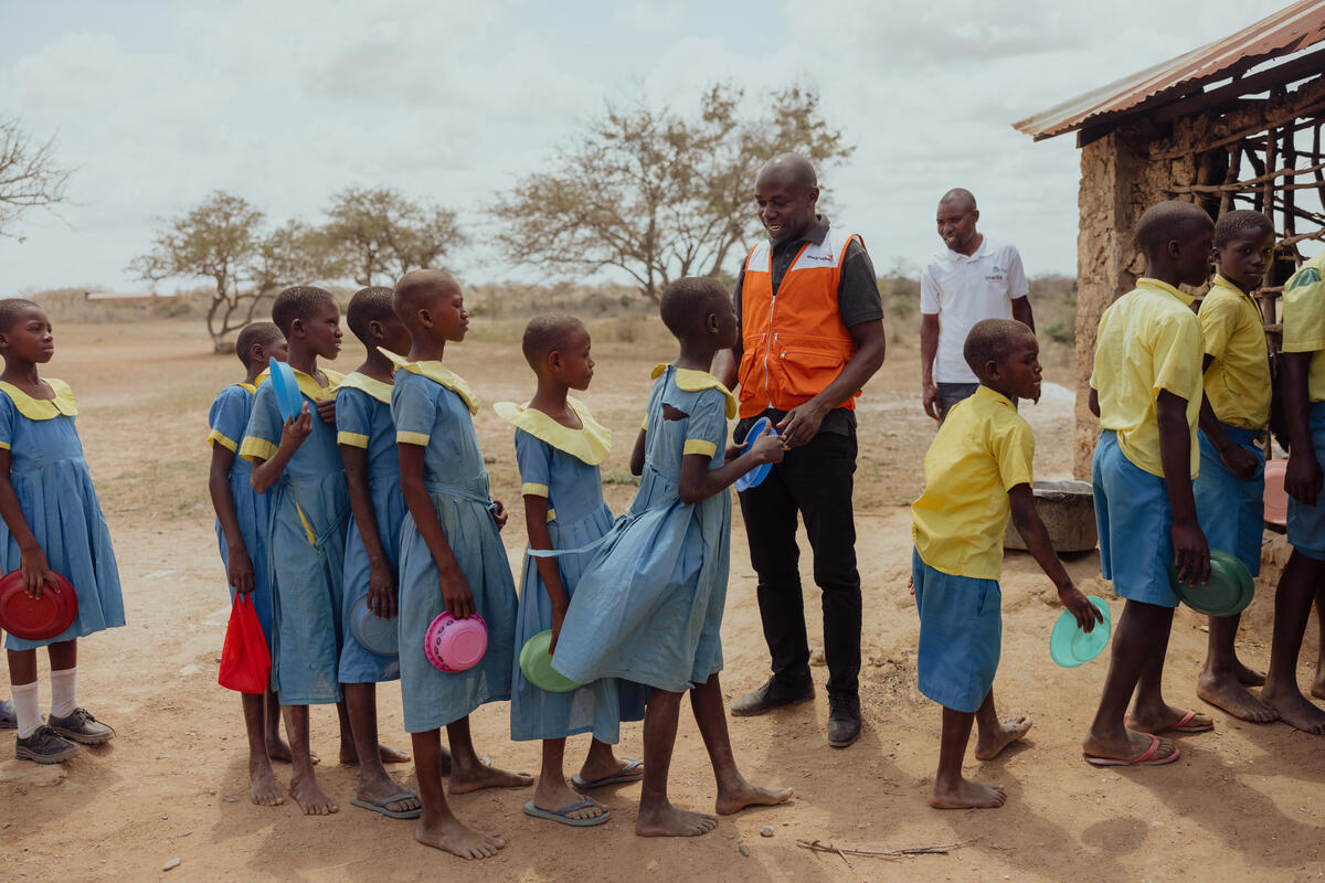Children in Kenya lining up for a school meal, as part of the community feeding programme.